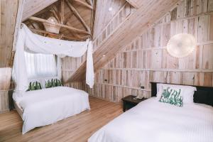 仁愛鄉的住宿－印象北歐莊園俱樂部，木墙客房的两张床