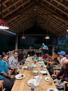 a group of people sitting around a long wooden table at Tiger Wildlife Resort in Bharatpur