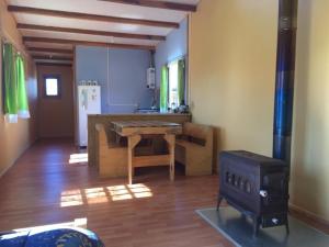 una cucina con tavolo in legno in una camera di Beautiful cabin in Patagonia Chile. a Chile Chico
