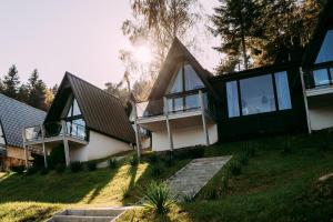 a house on a hill with glass doors and windows at NOI Resort SPA - woda i las in Tęgoborze