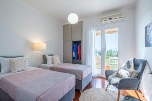 - une chambre avec deux lits, une chaise et une fenêtre dans l'établissement Likno Apartment, à Nauplie