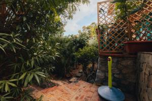 a garden with a mop and a brick walkway at Monia beach house in Santa Flavia