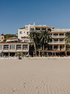 a hotel on the beach with palm trees in front of it at Voramar in Benicàssim