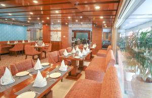 un comedor con mesas y sillas y una cafetería en Hotel Cama en Chandigarh