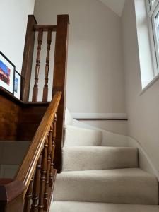 a staircase in a home with a wooden stair case at Cosy and lovely 4-Bed House in Stanmore in Stanmore