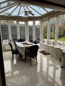 a conservatory with a table and chairs in it at Cosy and lovely 4-Bed House in Stanmore in Stanmore