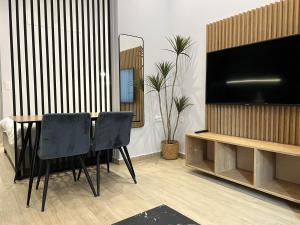 a dining room with a table and a flat screen tv at B1 Luxury Studio in Alexandroupoli