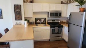a kitchen with white cabinets and a white refrigerator at Heart of Detroit Gem! 2BR Apt in Detroit