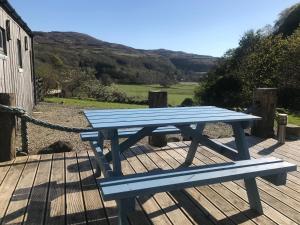 CalgaryCalgary Byre的一张蓝色野餐桌,坐在木甲板上