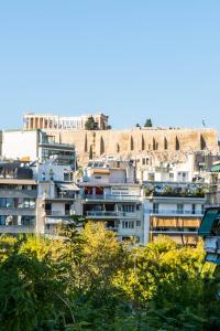 Un paysage urbain de bâtiments avec une colline en arrière-plan dans l'établissement Bright Modern Apt View of the Acropolis 5 min walk, à Athènes