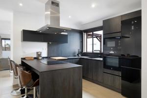 uma cozinha com armários pretos e um balcão preto em Casa El Molino em Yaiza