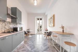 a kitchen with white cabinets and a table and chairs at Charming Apartment in the centre of Rome in Rome