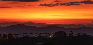 einen Sonnenuntergang mit den Bergen im Hintergrund in der Unterkunft Hotel Maranta in Pereira