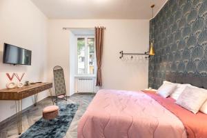 a bedroom with a pink bed and a desk at Charming Apartment in the centre of Rome in Rome