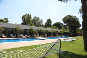 una piscina con una hamaca en un patio en Venosa Beach Resort & Spa - All Inclusive en Didim