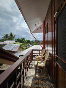 einen Balkon mit 2 Stühlen und Stadtblick in der Unterkunft Ferranco Tourist Inn in San Vicente