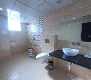 SīkarHotel Annpurna Regency的带水槽、马桶和镜子的浴室 更多37张照片