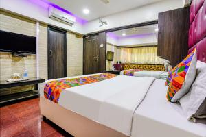 a bedroom with a large bed and a television at FabHotel King's Palace in Mumbai