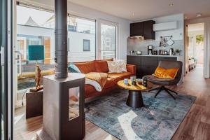 uma sala de estar com um sofá e um fogão a lenha em Schwimmendes Ferienhaus Cosy Home - Spreewald em Laasow