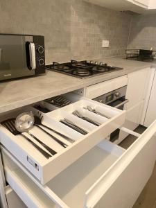 a kitchen with a stove and a microwave at Stylish Retreat By Aresti Hotels in London
