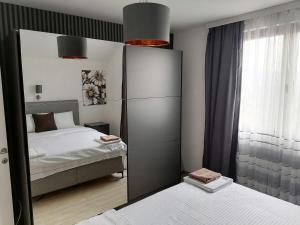 - une chambre avec 2 lits et un grand miroir dans l'établissement Apartmani Lane 1, à Kraljevo