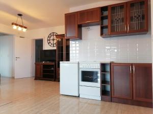 a kitchen with white appliances and wooden cabinets at Apartmani Lane 1 in Kraljevo
