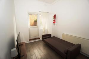 a living room with a couch and a window at Stylish Retreat By Aresti Hotels in London