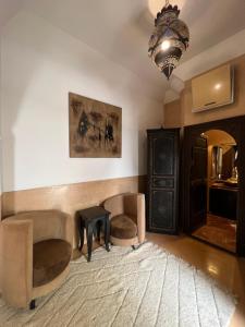 a living room with a couch and a table and a chandelier at Riad Des Arts in Marrakesh