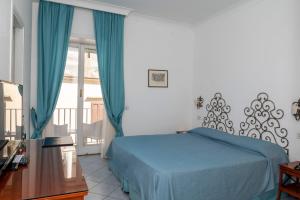 a bedroom with a blue bed and a balcony at Palatium Mari in Capri