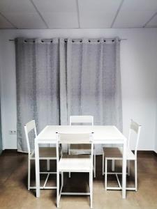 un tavolo bianco con sedie in una stanza con tende di Albergue La Paz de Las Alpujarras a Padules