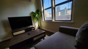 a living room with a flat screen tv and a couch at Heart of Detroit Gem! 2BR Apt in Detroit