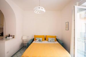 a bedroom with a bed with yellow pillows at Blue Vert Maison - al molo di Gaeta in Gaeta