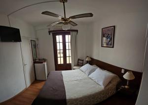 a bedroom with a bed and a ceiling fan at Hotel Budapest in Piriápolis