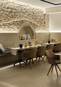 a restaurant with tables and chairs and a stone wall at GUT & GASTLICH Stallmann-Hiestand in Uelversheim
