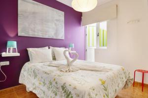 una camera da letto con pareti viola e un letto con un cigno sopra di Lanzarote Beach ad Arrecife