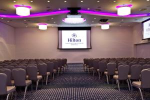 a lecture hall with chairs and a screen at Hilton London Heathrow Airport Terminal 5 in Hillingdon