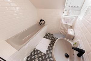 uma casa de banho branca com uma banheira e um WC em Penzion POSADA em Podivín