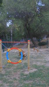 a dog is tied to a swing in a park at Pugnochiuso Resort Hotel del Faro in Vieste