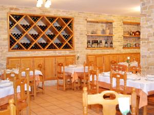 a restaurant with tables and chairs with wine bottles at Hotel Moregón in Cuacos de Yuste