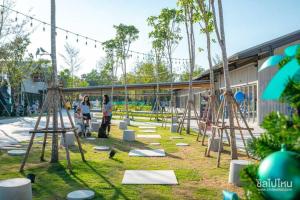 a group of people standing in a park with swings at Bangtao - Laguna center, 1BR, Near Laguna Center in Ban Thalat Choeng Thale