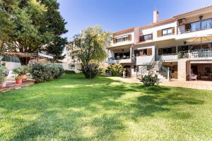 a large yard in front of a building at Paradise Suites in Carcavelos
