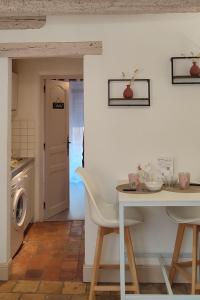 eine Küche und ein Esszimmer mit einem Tisch und einer Waschmaschine in der Unterkunft Blois City - Le Petit Saint Jean in Blois