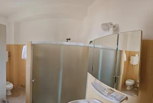 a bathroom with a shower and a sink and a mirror at Hotel Budapest in Piriápolis