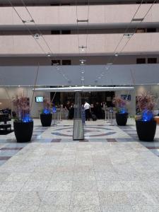 an empty lobby with blue plants in a building at Bristol International Airport Hotel - Guarulhos apto 1267 in Guarulhos
