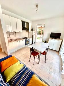 a kitchen with a table and a dining room at Appartamenti Mac, trilocali vicino al mare con posto auto in Marcelli +35 photos