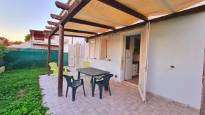 a patio with a table and chairs under a pergola at Appartamenti Mac, trilocali vicino al mare con posto auto in Marcelli
