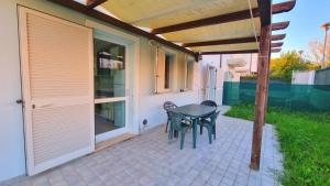 a patio with two chairs and a table on the side of a house at Appartamenti Mac, trilocali vicino al mare con posto auto in Marcelli