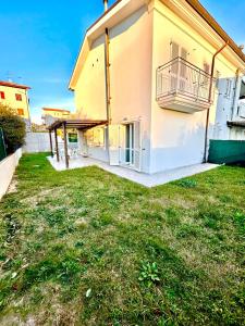 a building with a grass yard in front of it at Appartamenti Mac, trilocali vicino al mare con posto auto in Marcelli