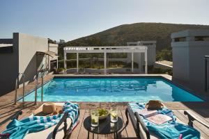 a swimming pool on top of a building with a mountain at The Den Apartments by Raw Africa Collection in Stellenbosch