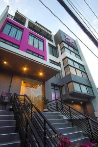 un bâtiment rose et blanc avec des escaliers devant dans l'établissement OYO 1030 Ai Hotel, à Manille